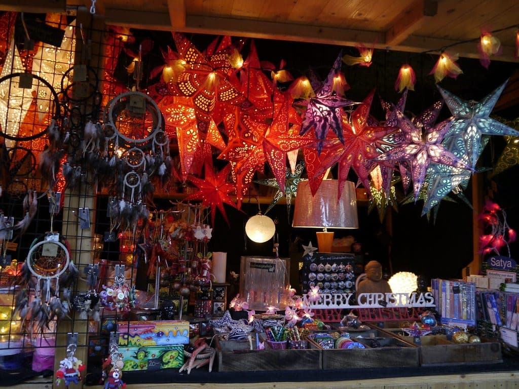 Paper star lanterns glow above a craft stall at a Christmas market in Bern