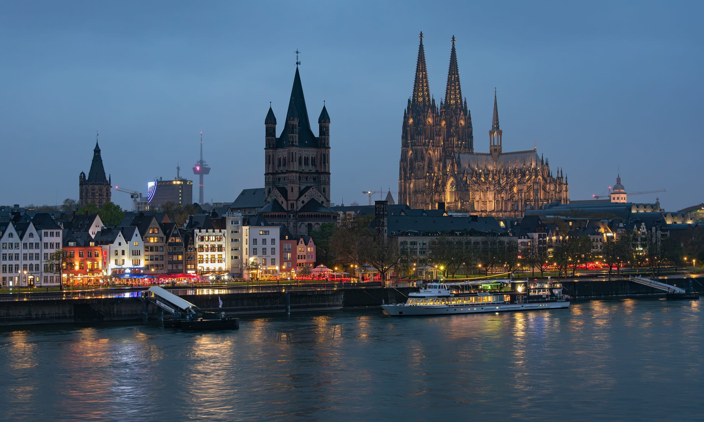 Great St Martin and Cologne Cathedral rise above the old town on the Rhine at blue hour