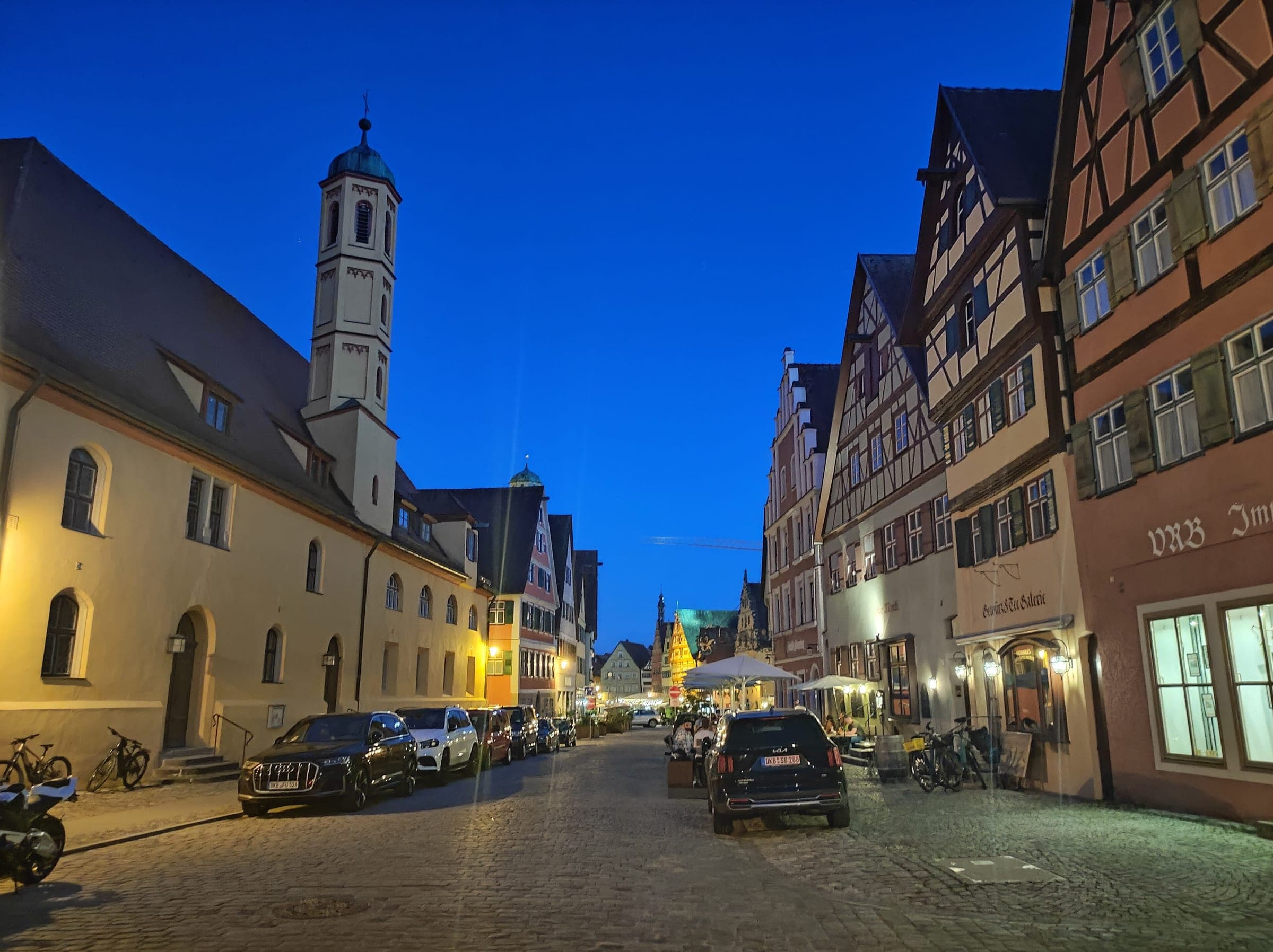 Half-timbered houses and a church tower line Dr.-Martin-Luther-Straße in Dinkelsbühl at blue hour