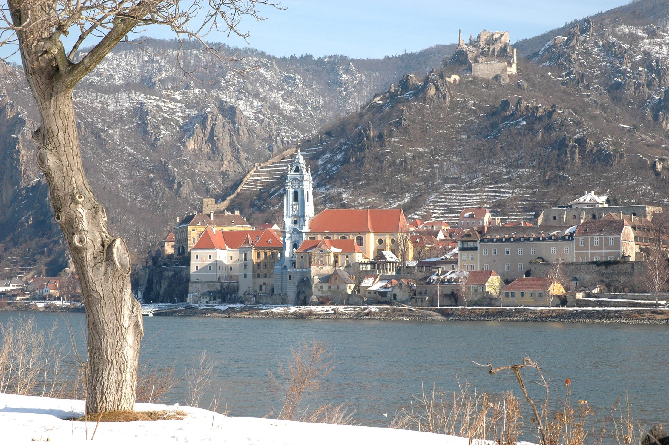Snow dusts the slopes above Durnstein and its blue abbey tower across the Danube in winter.