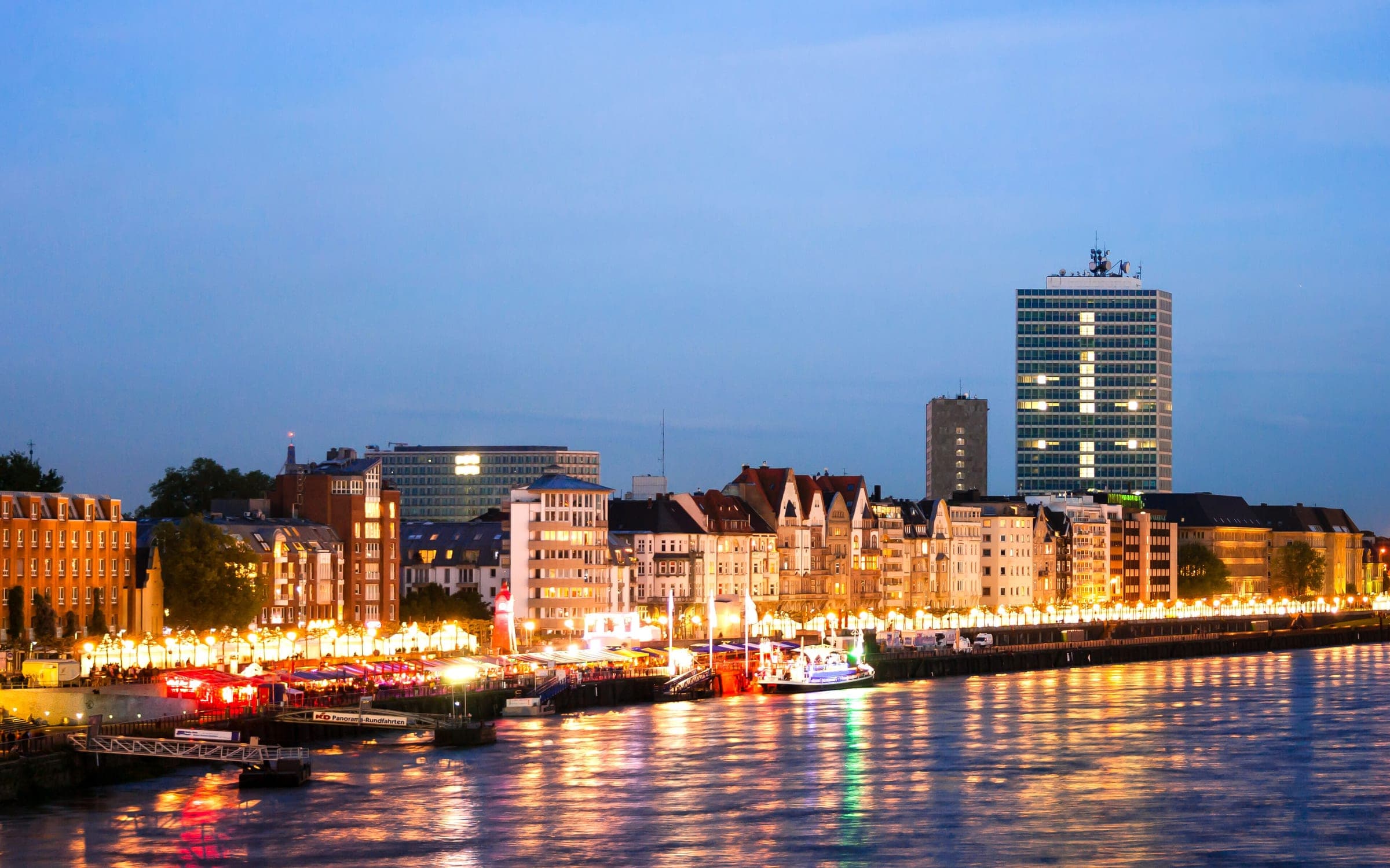 Lights along the Rathausufer reflect in the Rhine below Düsseldorf's Altstadt in the evening