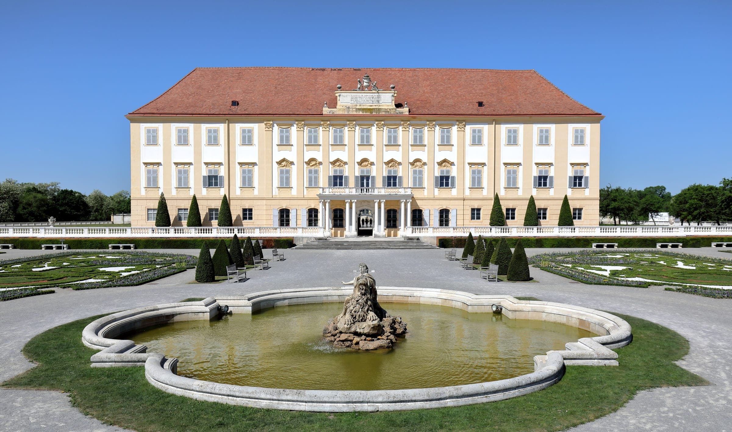 Schloss Hof rises behind its Baroque fountain and clipped gardens in Engelhartstetten under a clear sky.
