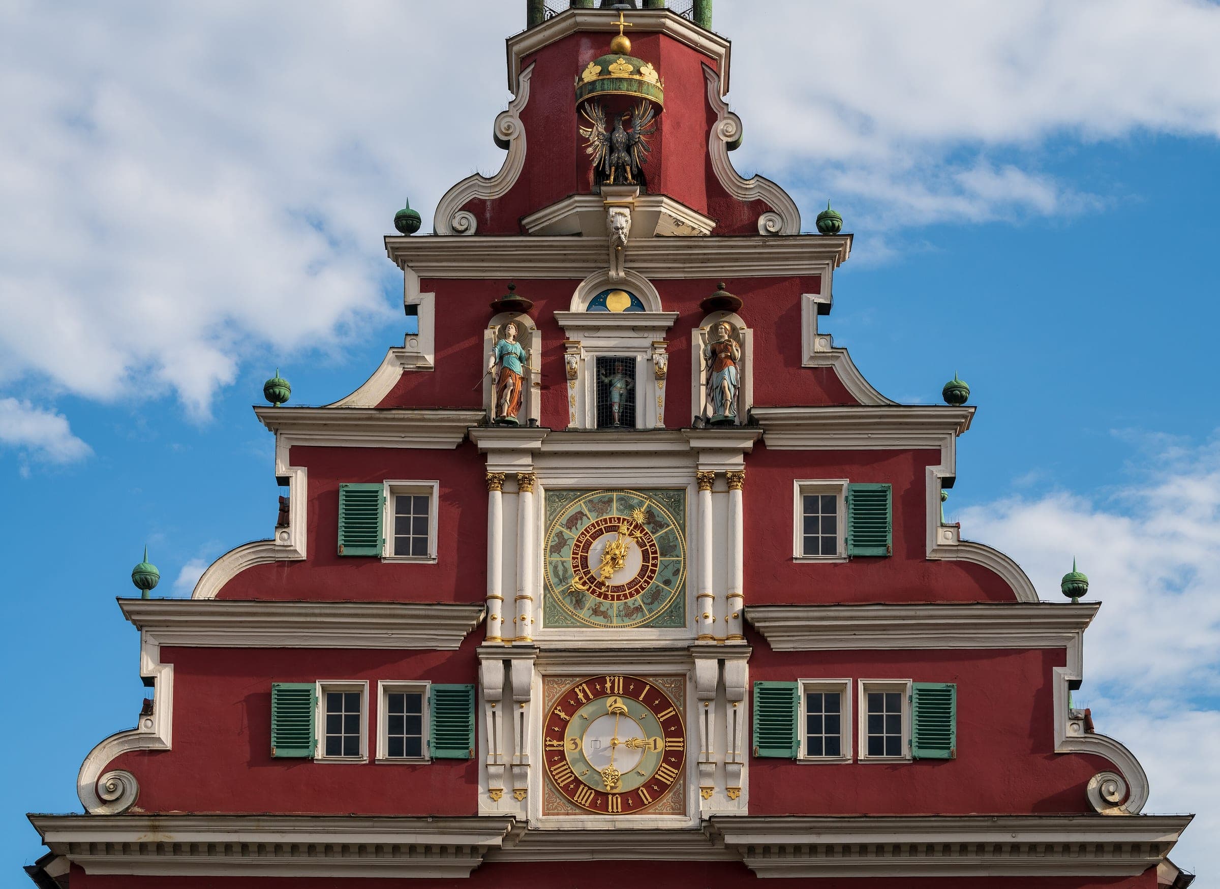 The Renaissance gable of Esslingen's Altes Rathaus carries two clocks and painted figures under a blue sky.