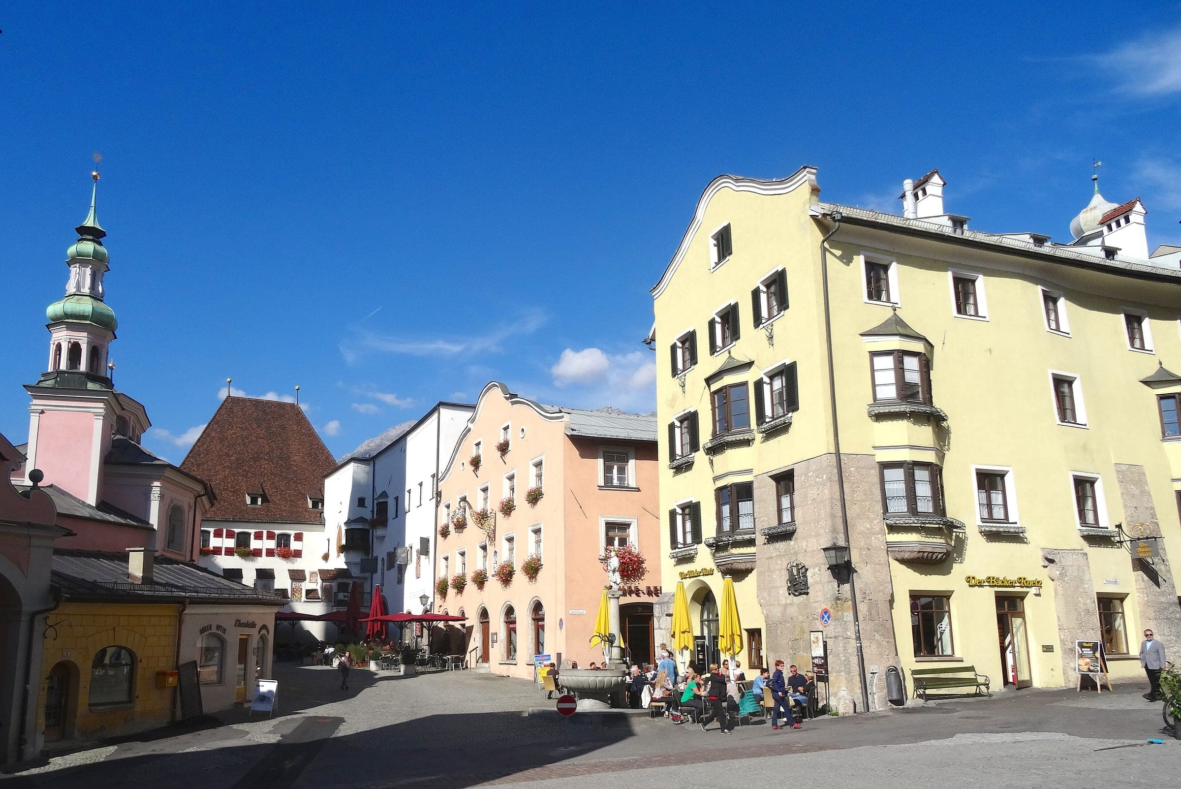 Pastel townhouses with oriels frame the Oberer Stadtplatz in Hall in Tirol on a sunny autumn day.