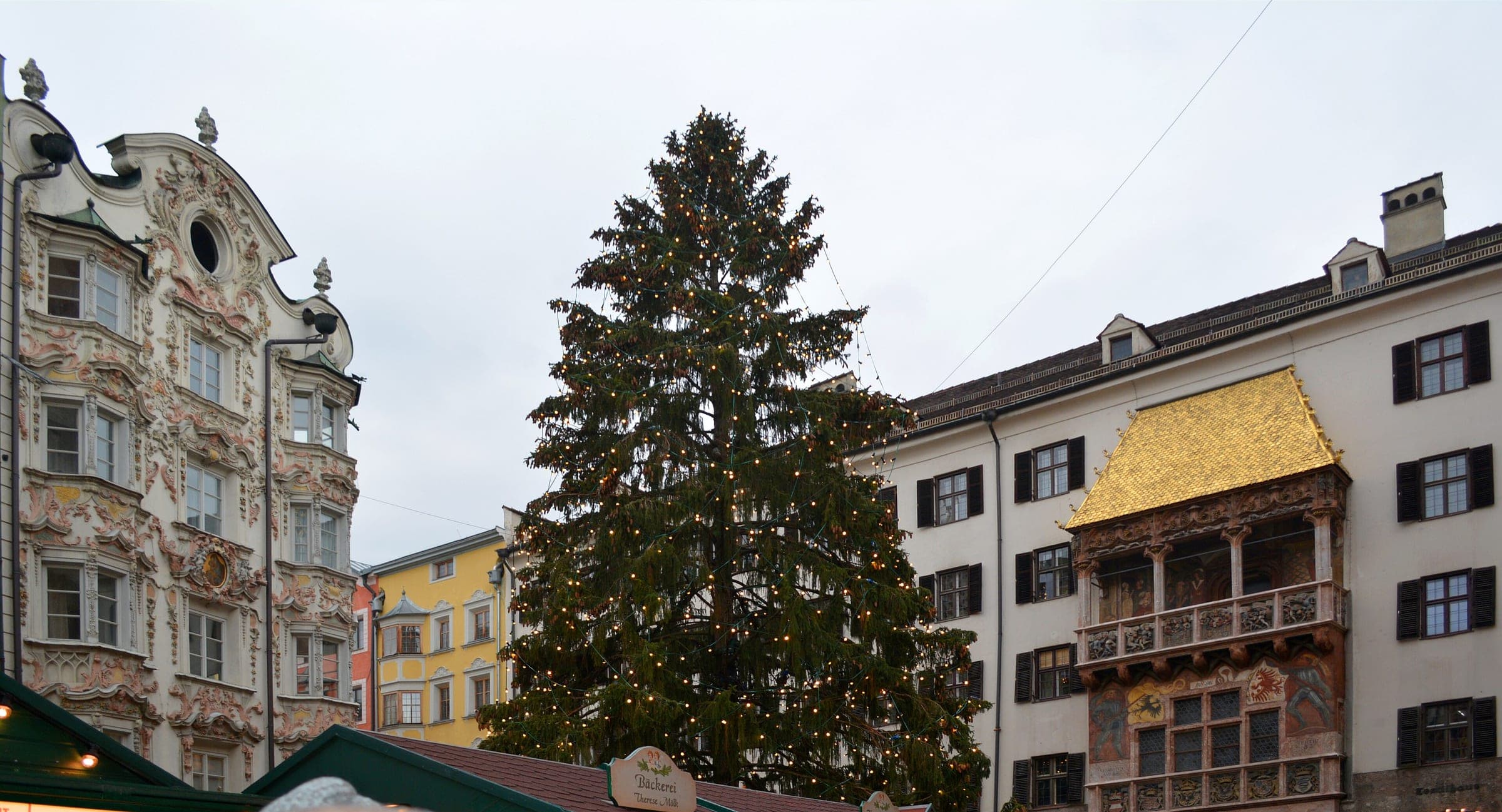 The Christmas tree stands between the stucco Helblinghaus and the Golden Roof in Innsbruck's old town.