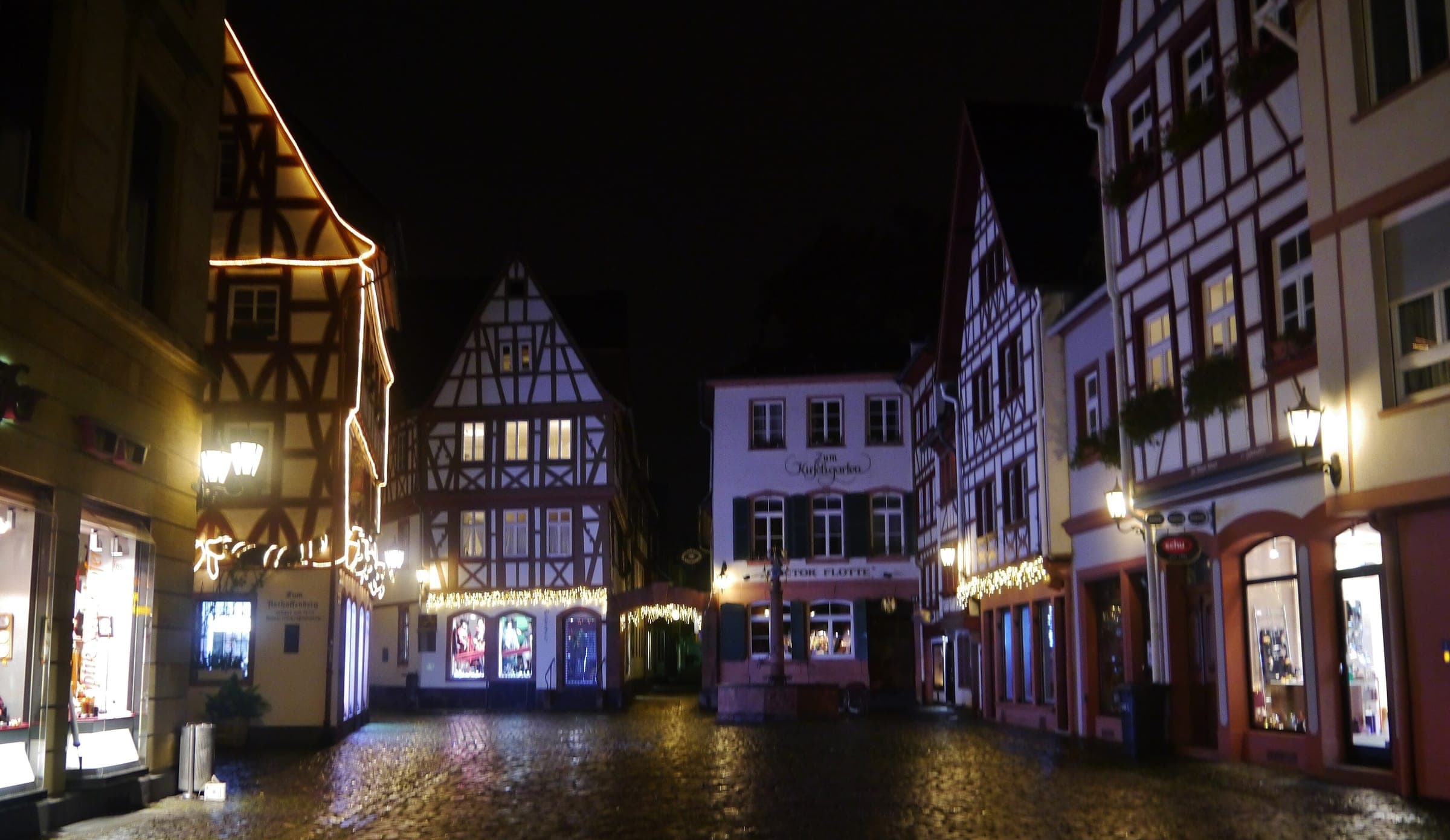 Christmas lights trace the timber-framed houses around the Kirschgarten in Mainz's old town at night.