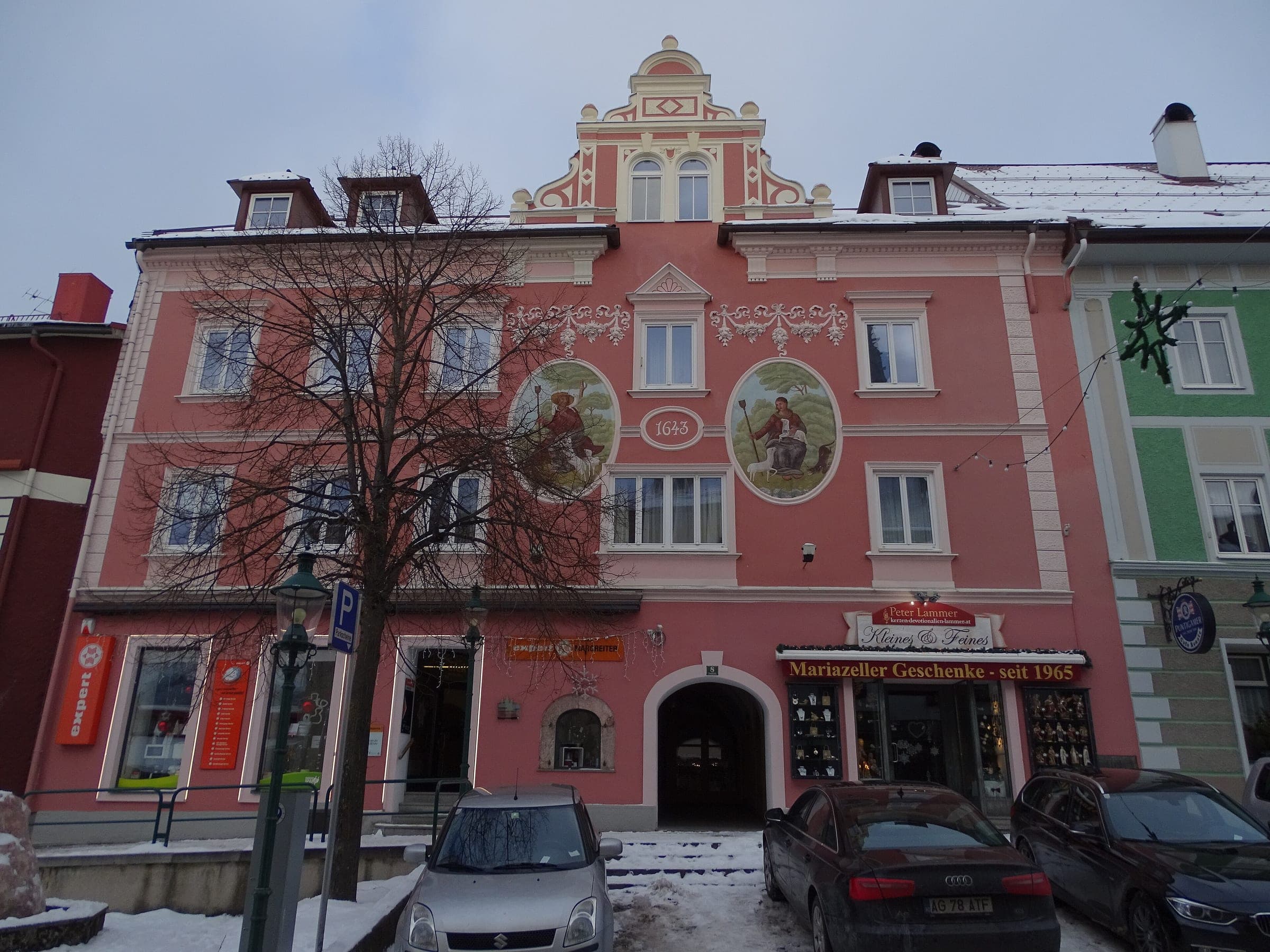 A painted pink townhouse with a stepped gable stands on Wiener Straße in Mariazell in December.