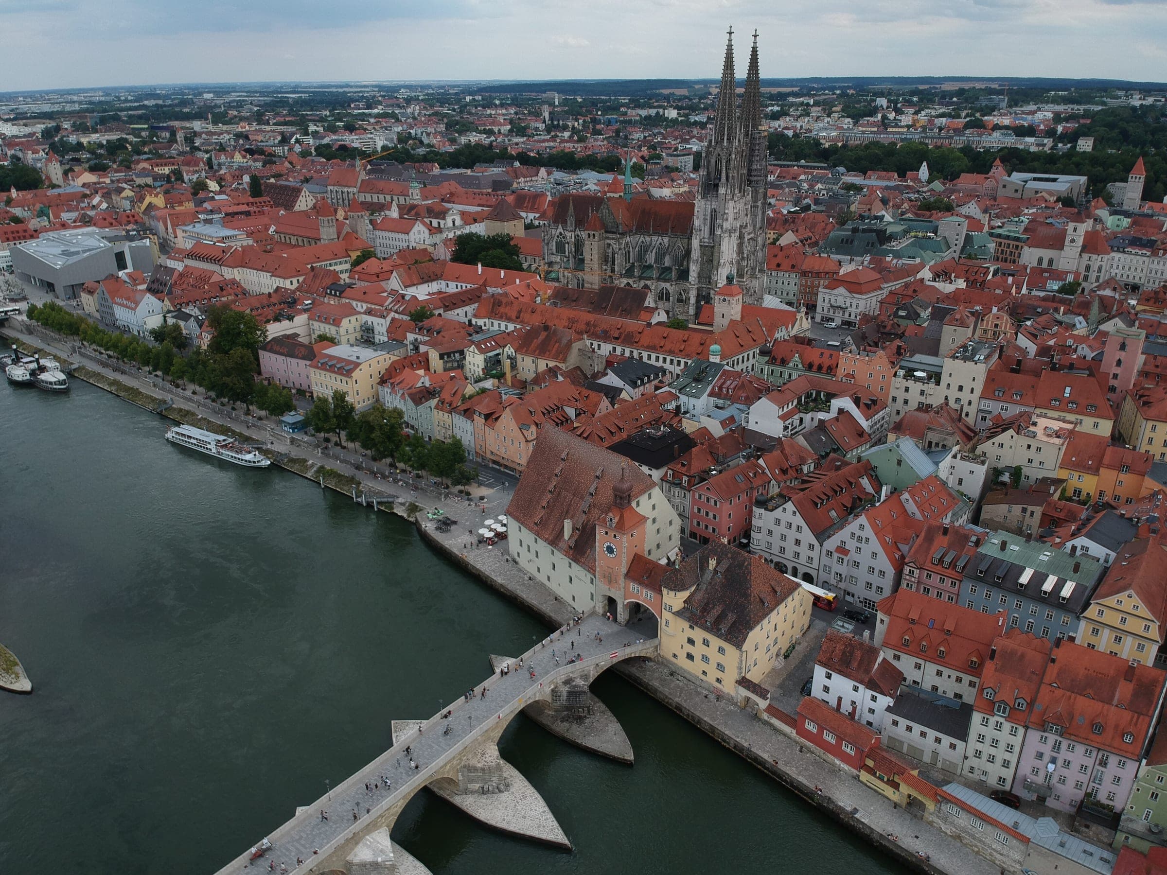 Red roofs of Regensburg's old town run down to the Stone Bridge and the Danube below the cathedral.