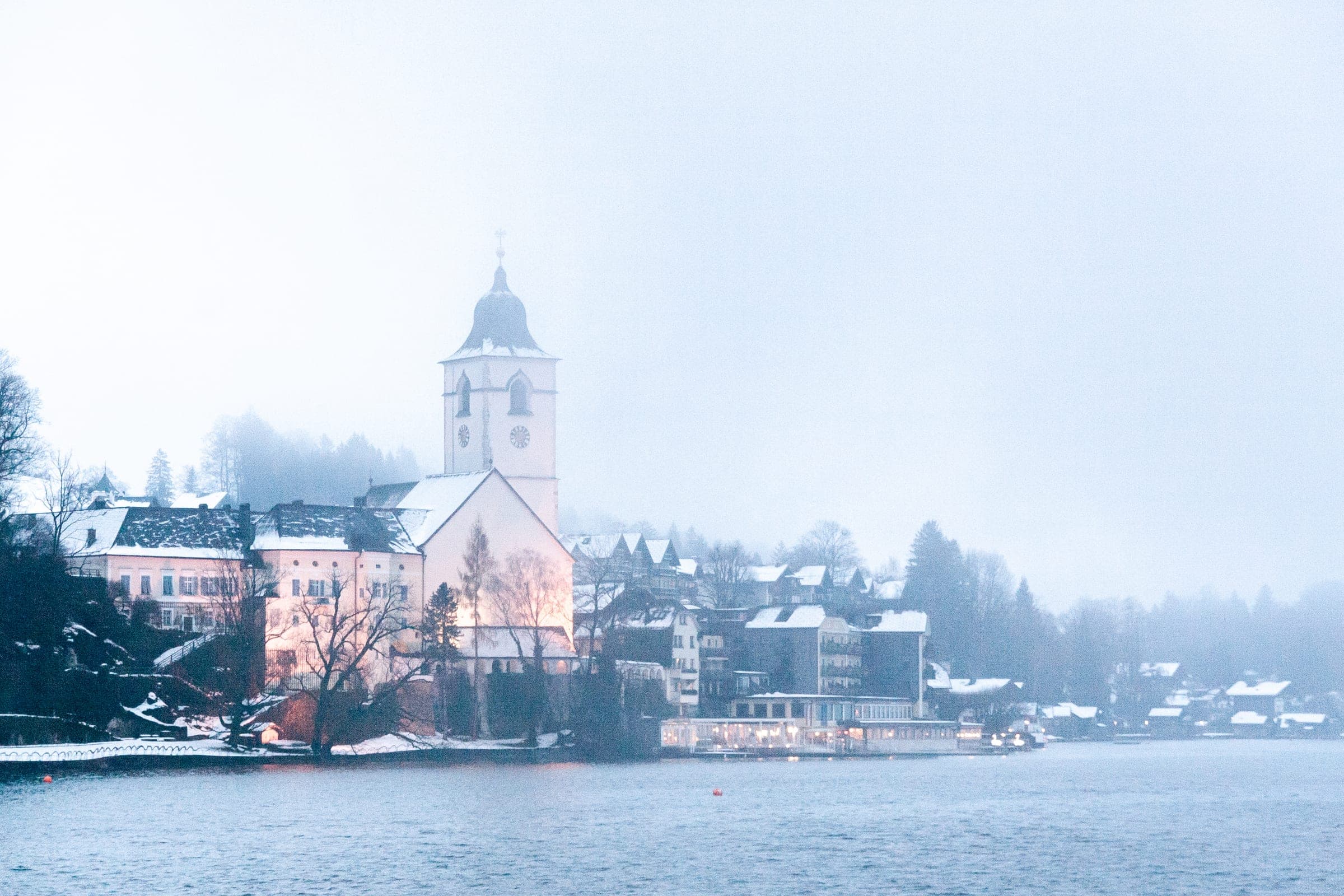December mist hangs over the Wolfgangsee and the pilgrimage church tower of St Wolfgang