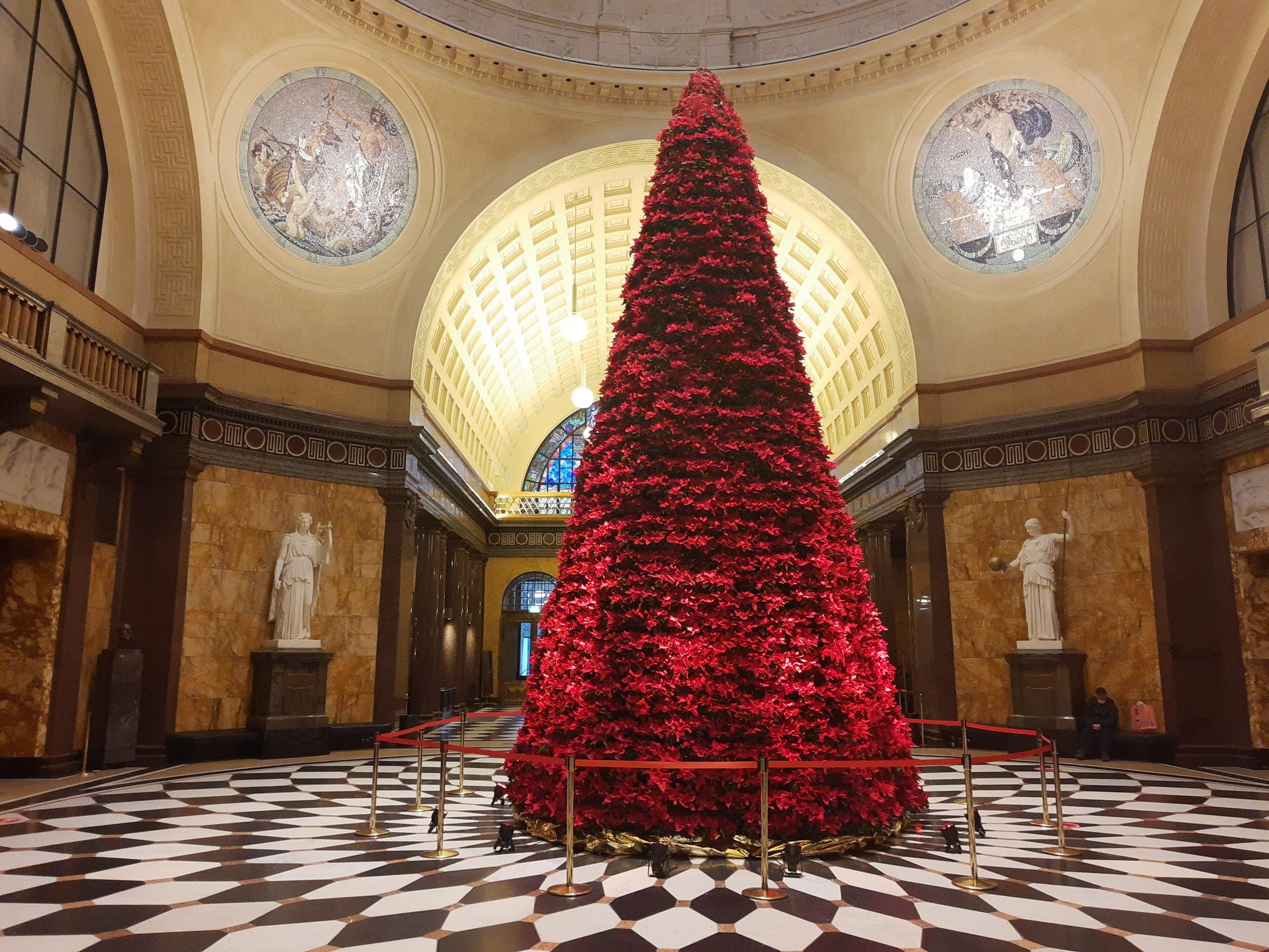 A tall red Christmas tree fills the domed foyer of the Kurhaus in Wiesbaden on its marble floor.