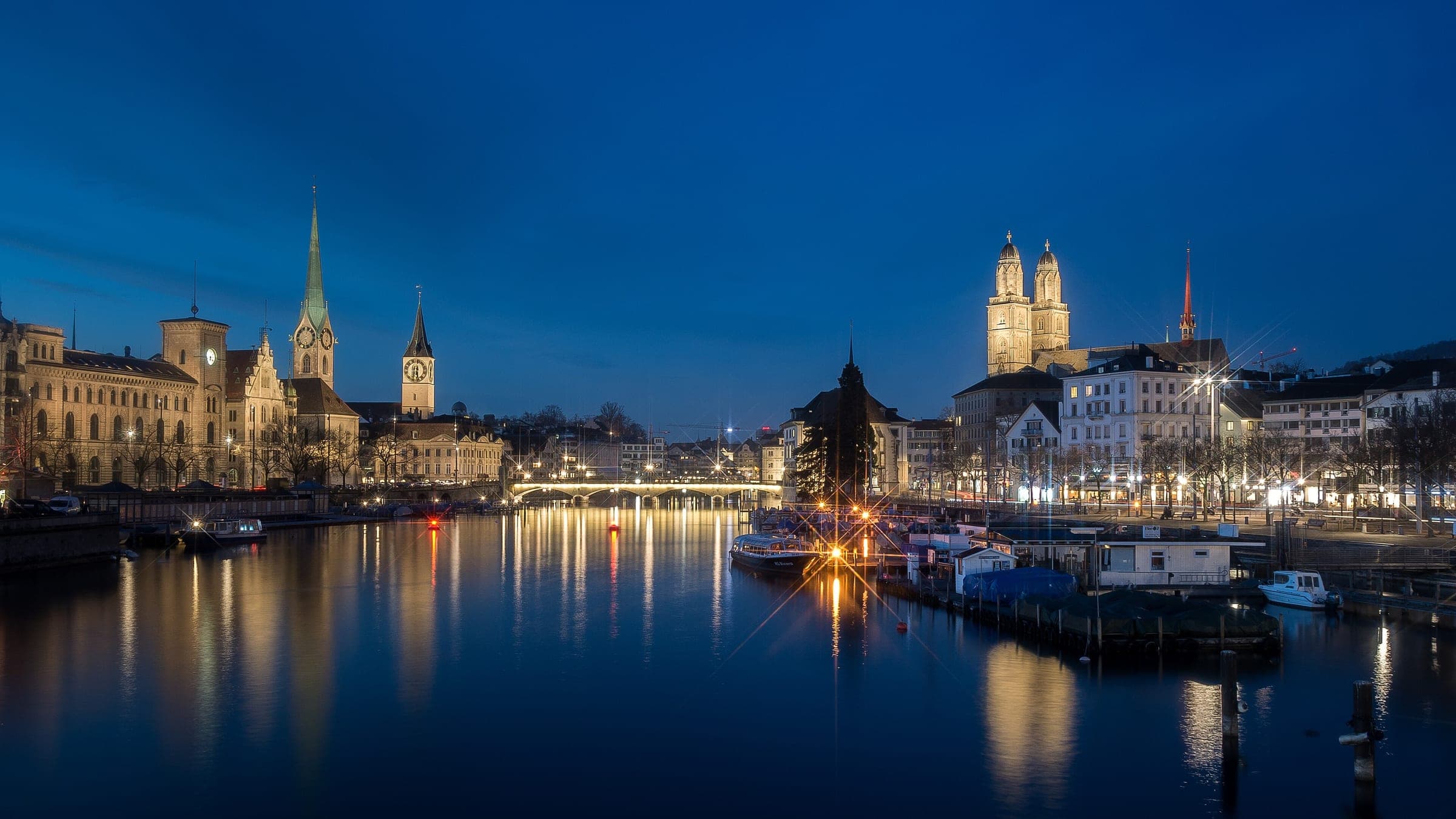 The Limmat runs between Fraumünster, St. Peter and the Grossmünster in Zurich at blue hour in January