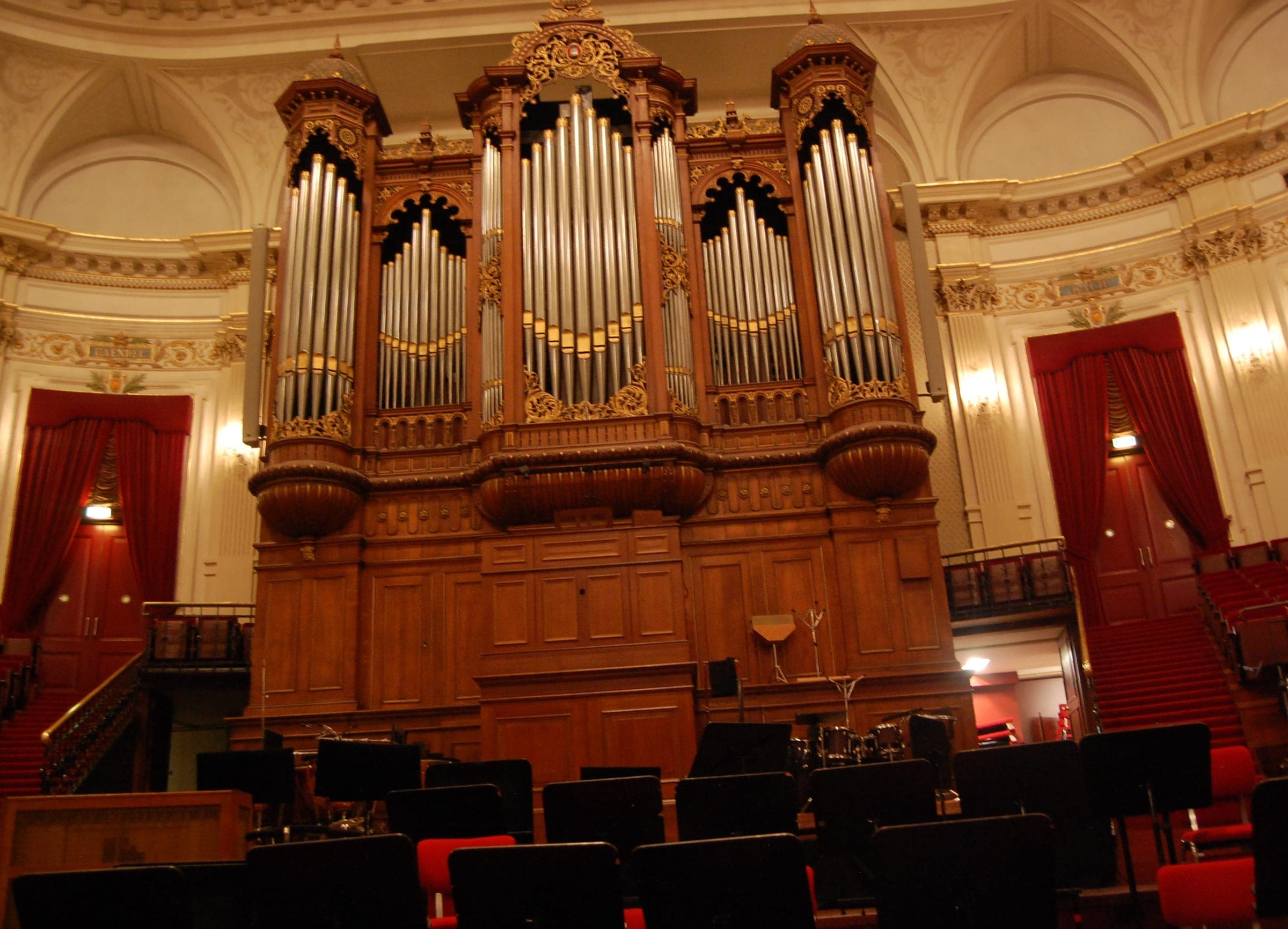 Music stands wait on the stage of the Concertgebouw's main hall in Amsterdam below the gilded organ.