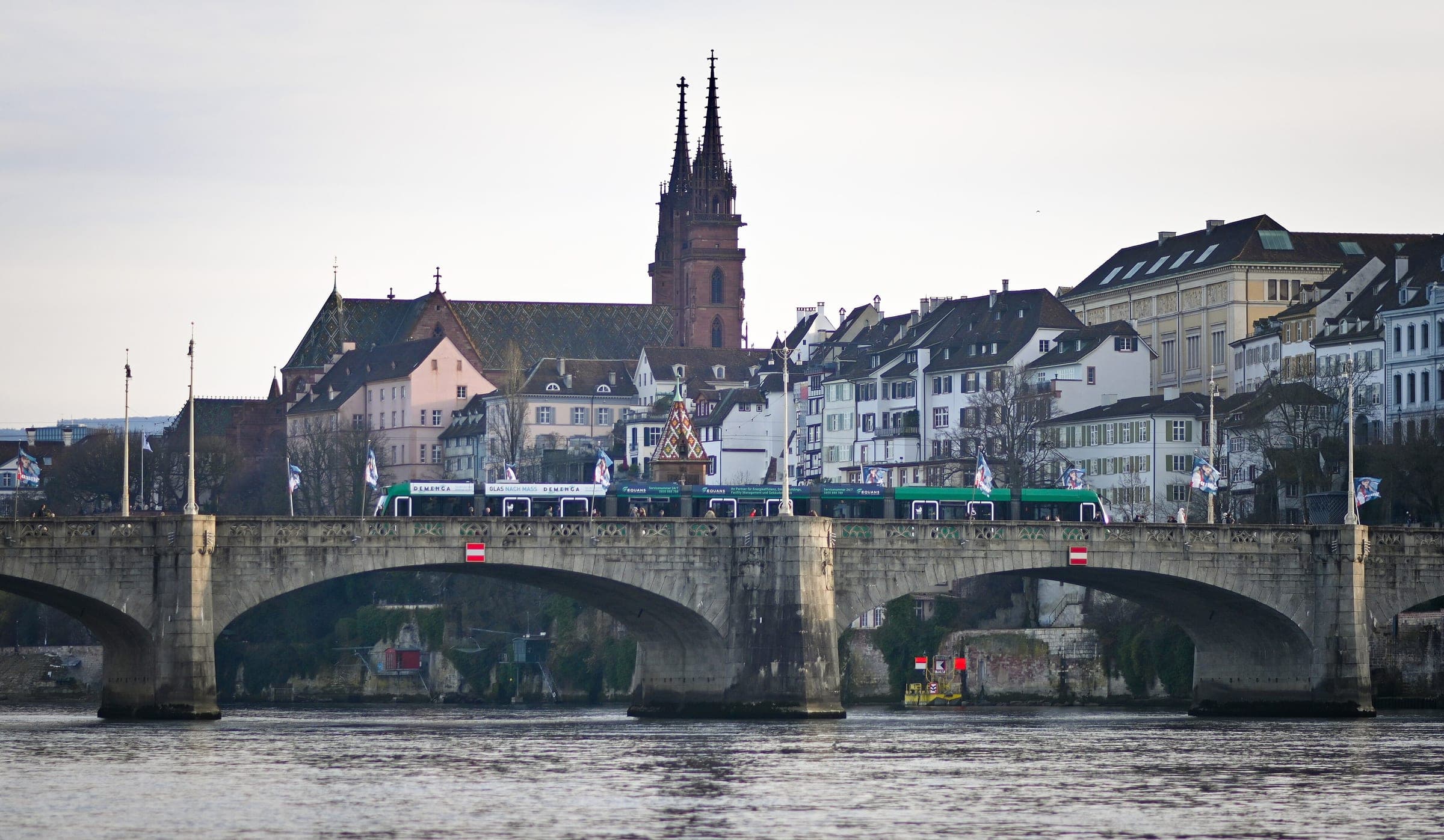 Basel Minster rises above the Rhine houses and the Mittlere Brücke on a grey January day