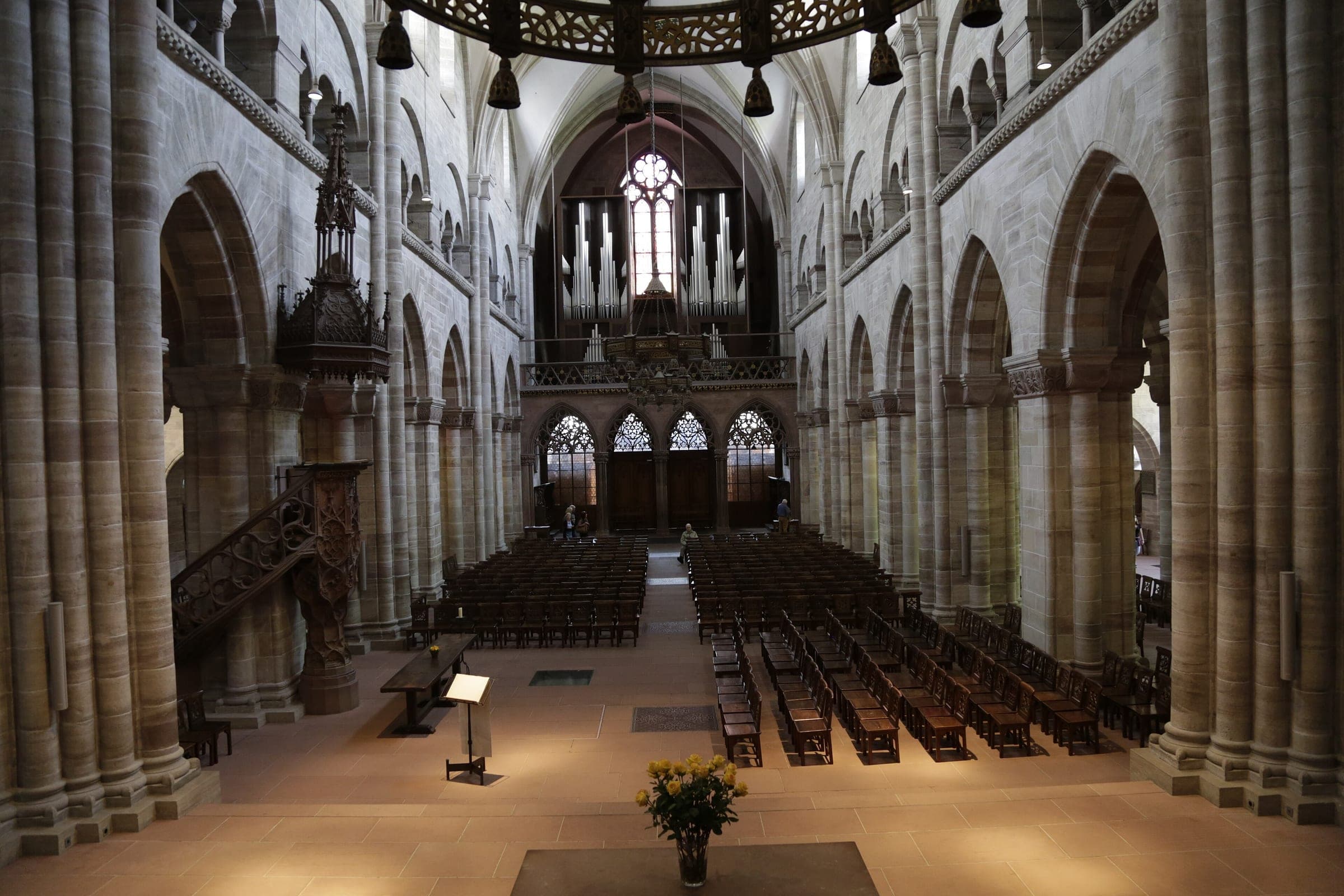 The Gothic nave of Basel Minster runs between red sandstone piers toward the organ and the west rose
