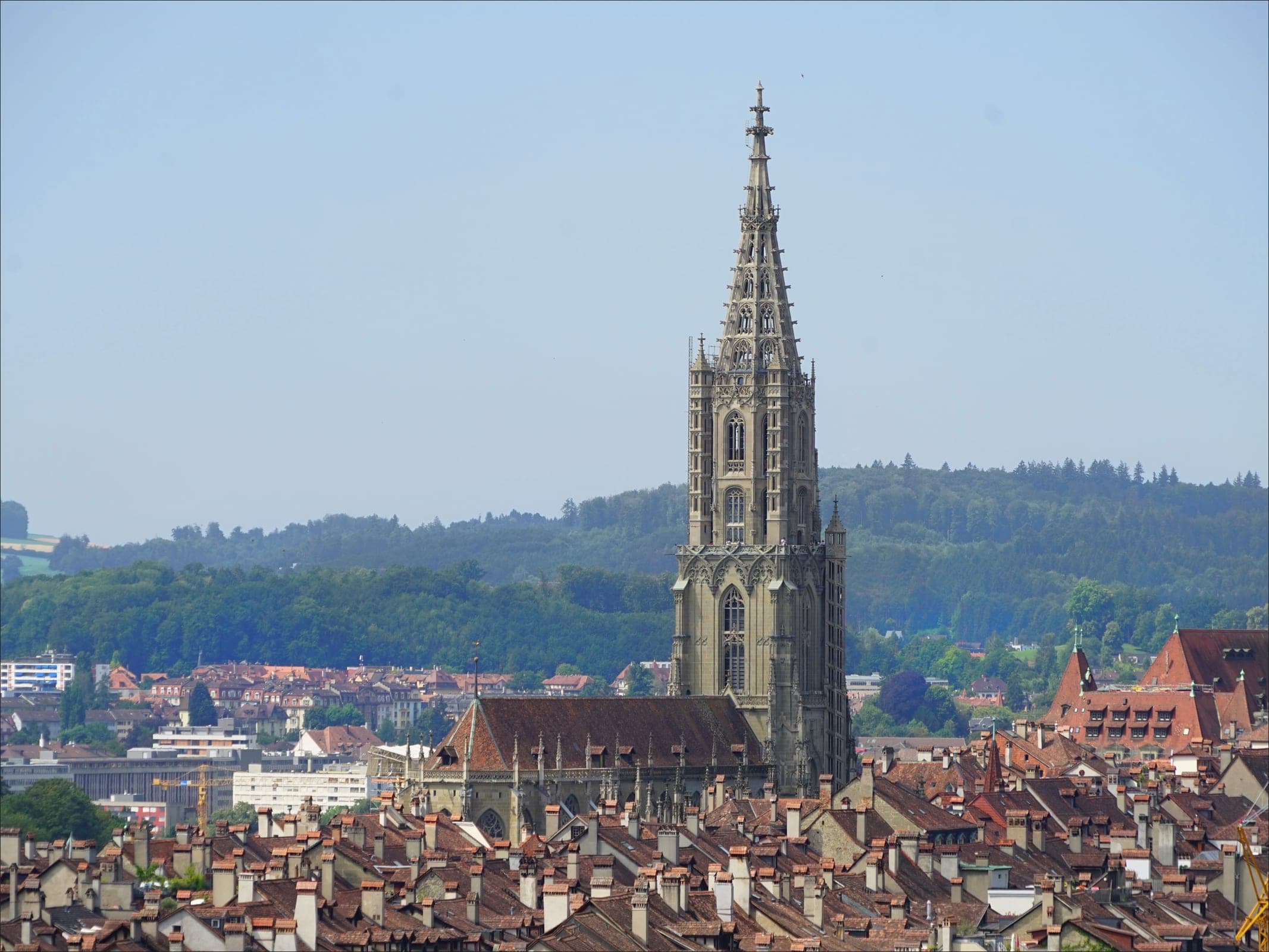 The tower of Bern Minster rises above the tiled roofs of the old town