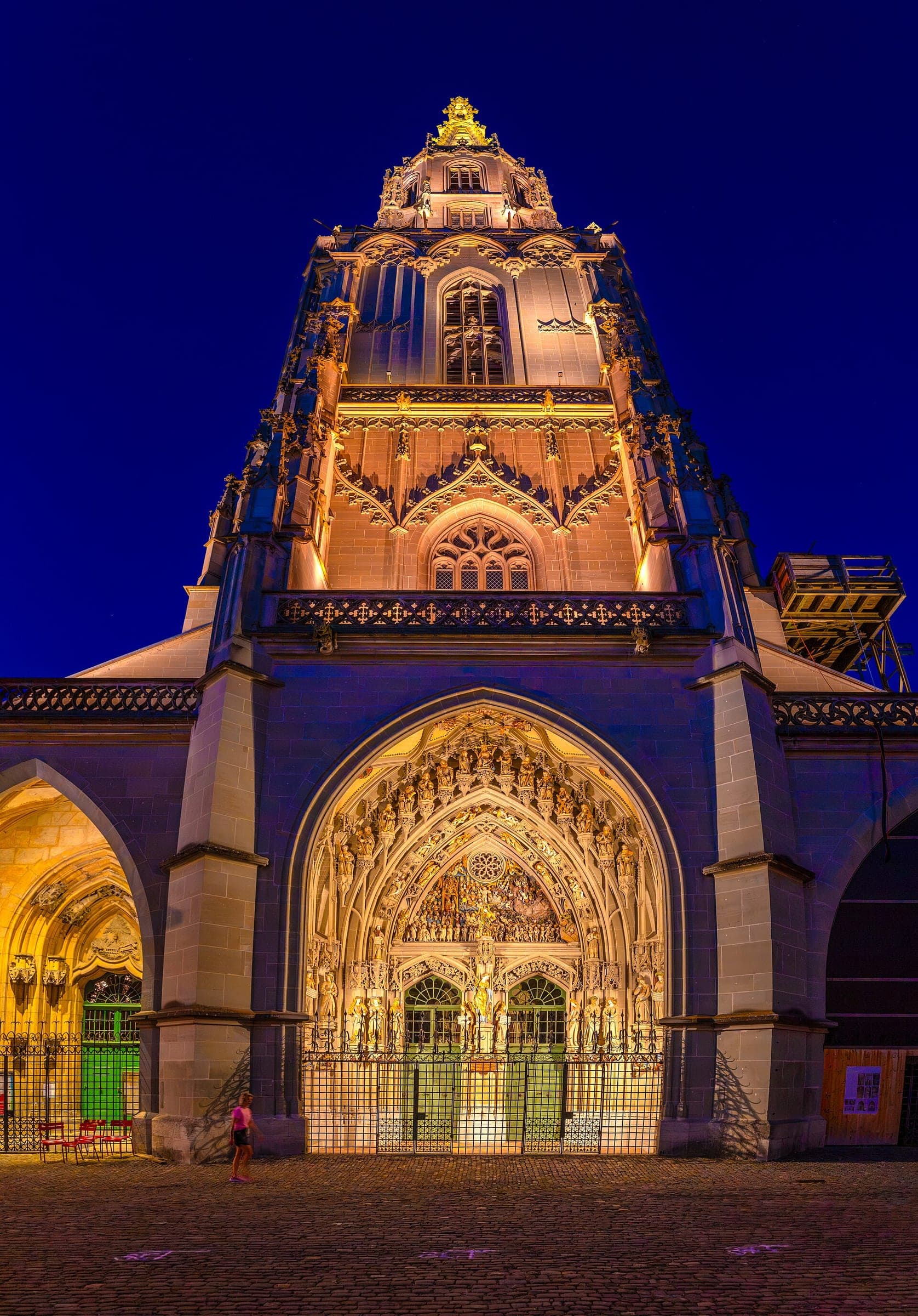 Floodlights pick out the tower and main portal of Bern Minster at blue hour