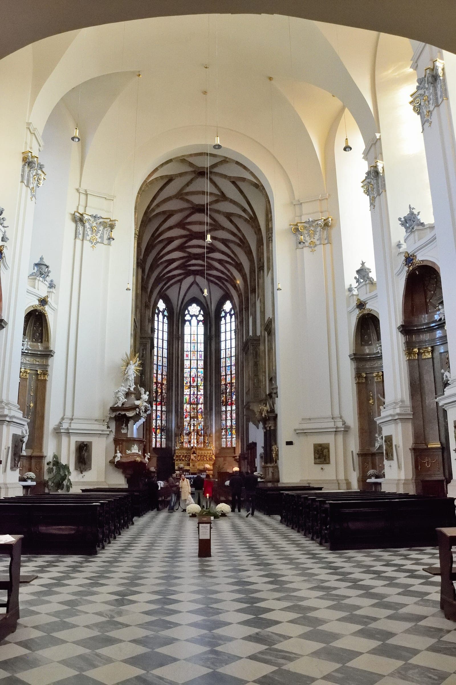 Tall stained-glass windows close the white nave of the Cathedral of Saints Peter and Paul in Brno.