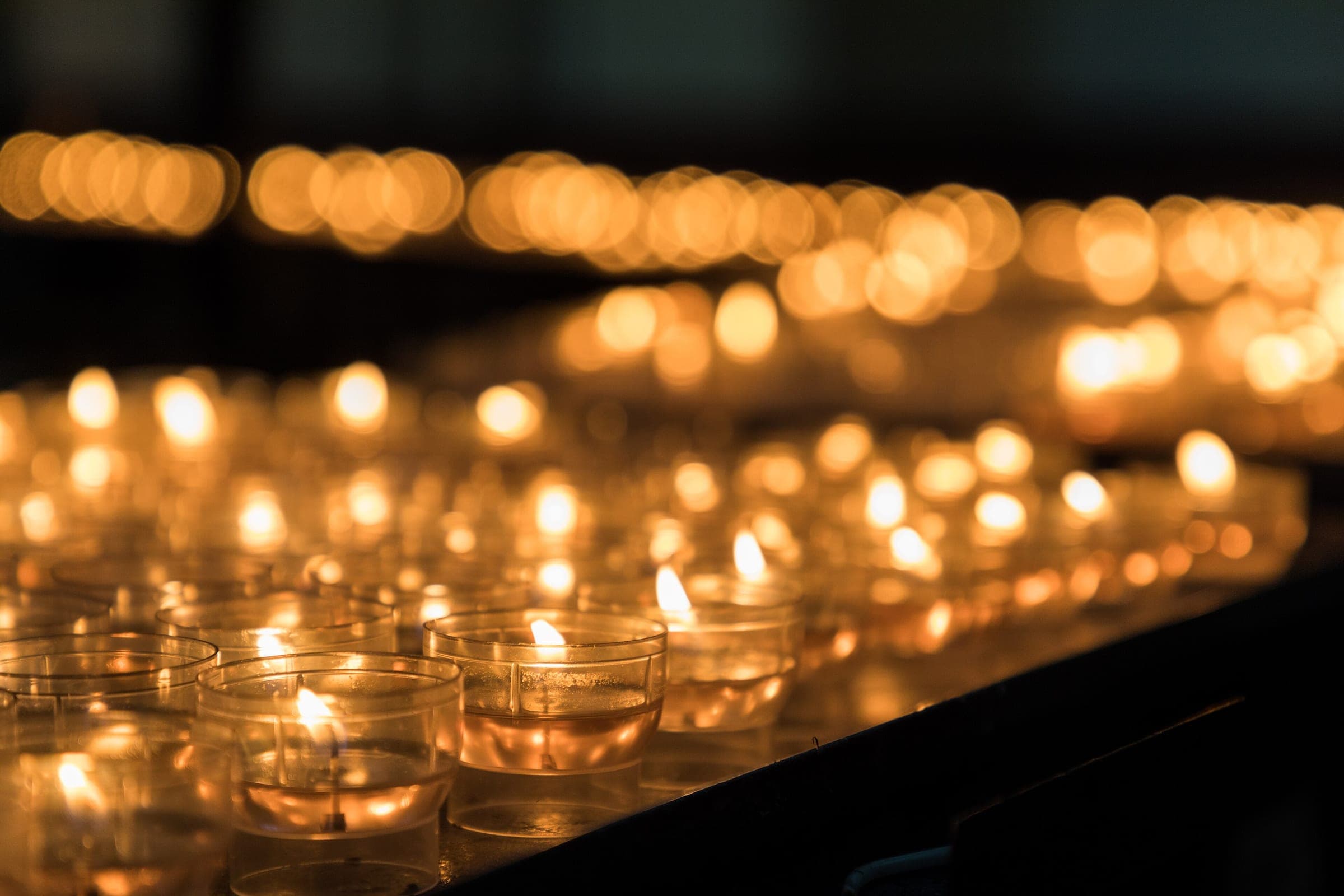 Rows of votive candles burn in glass holders inside St Salvator's Cathedral in Bruges.