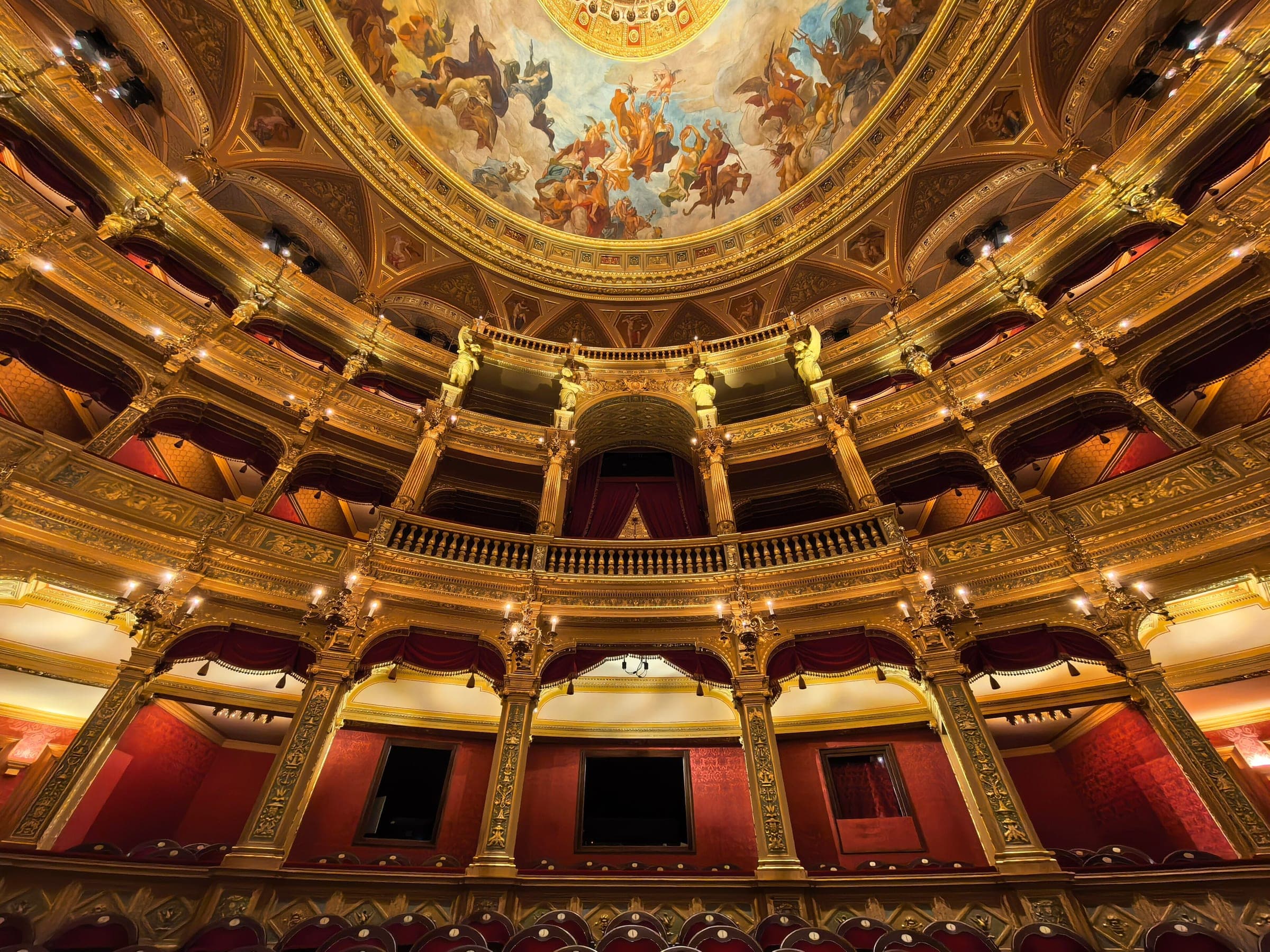 Gilded tiers of boxes curve around the red auditorium of the Hungarian State Opera House in Budapest.
