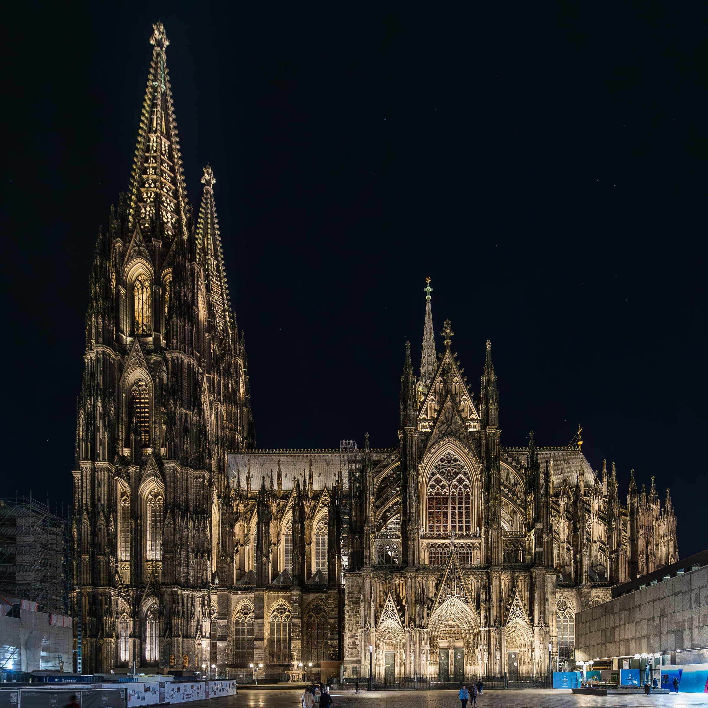 Floodlights pick out the south transept and tower of Cologne Cathedral above an empty Roncalliplatz