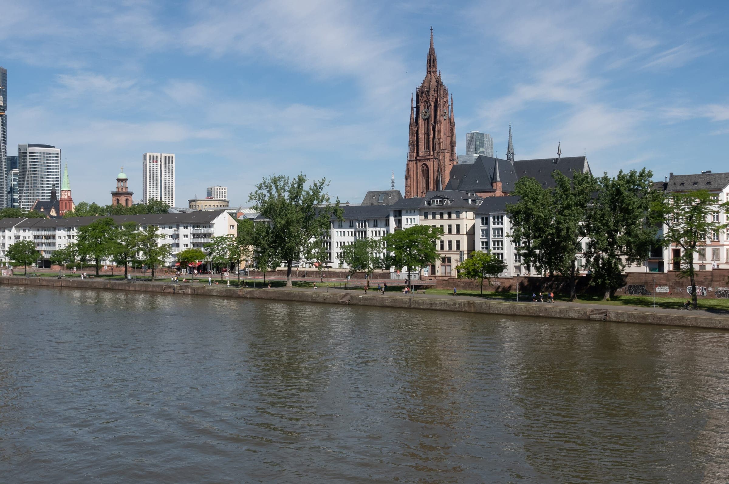Frankfurt Cathedral's tower stands above the old town roofs across the river Main.