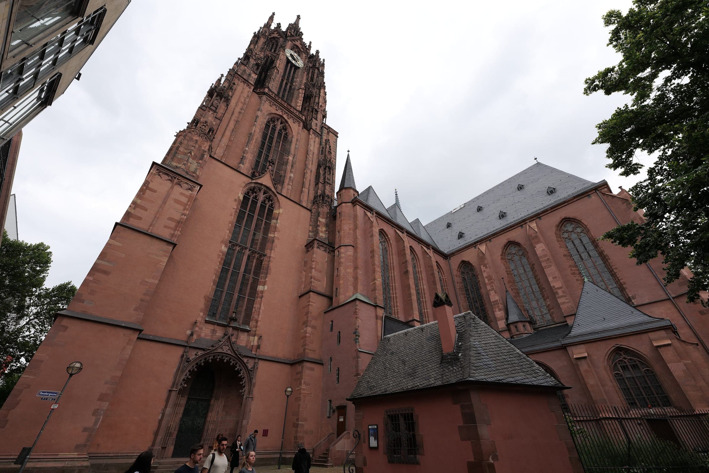 The red sandstone tower and nave of Frankfurt Cathedral rise over the square on its south side.