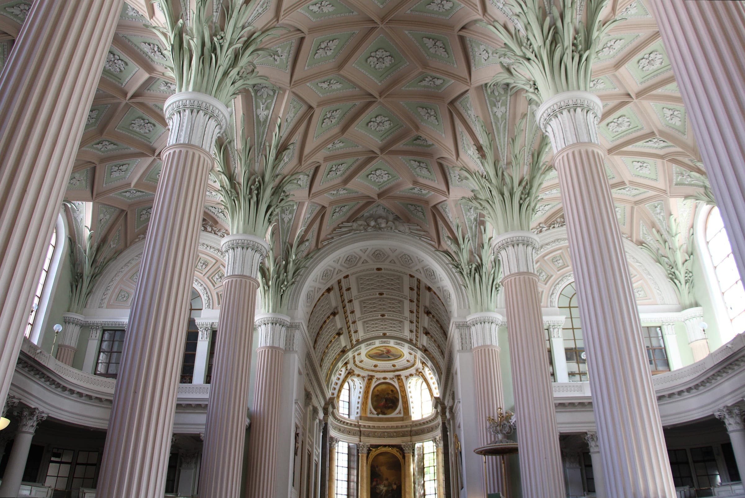 Palm-topped white columns hold up the pastel vault of the nave in Leipzig's Nikolaikirche.