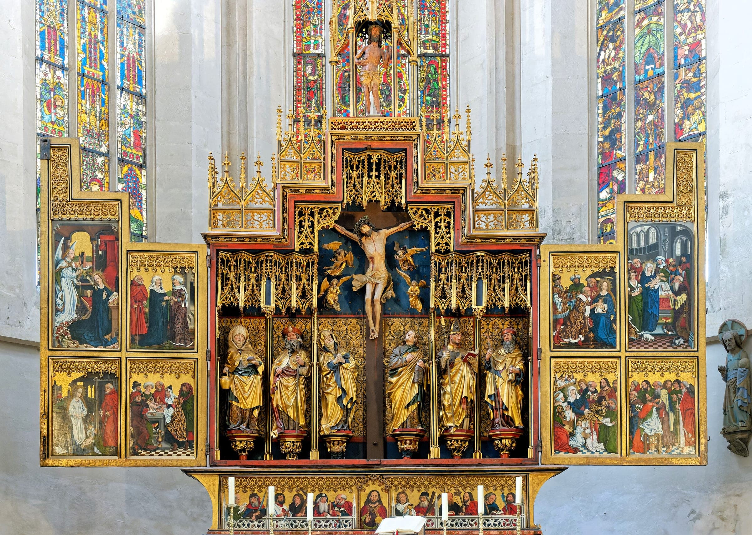 Painted wings and carved saints fill the Gothic high altar in front of the choir windows of St. Jakob in Rothenburg
