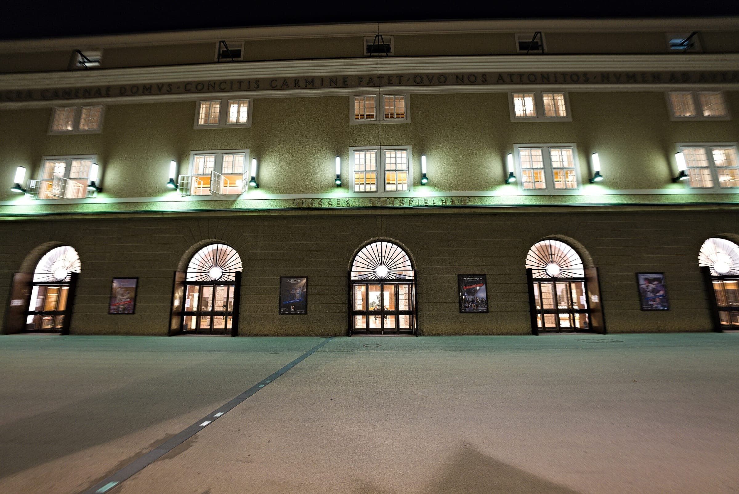 Lamps light the arched doors of the Grosses Festspielhaus on Salzburg's Hofstallgasse at night