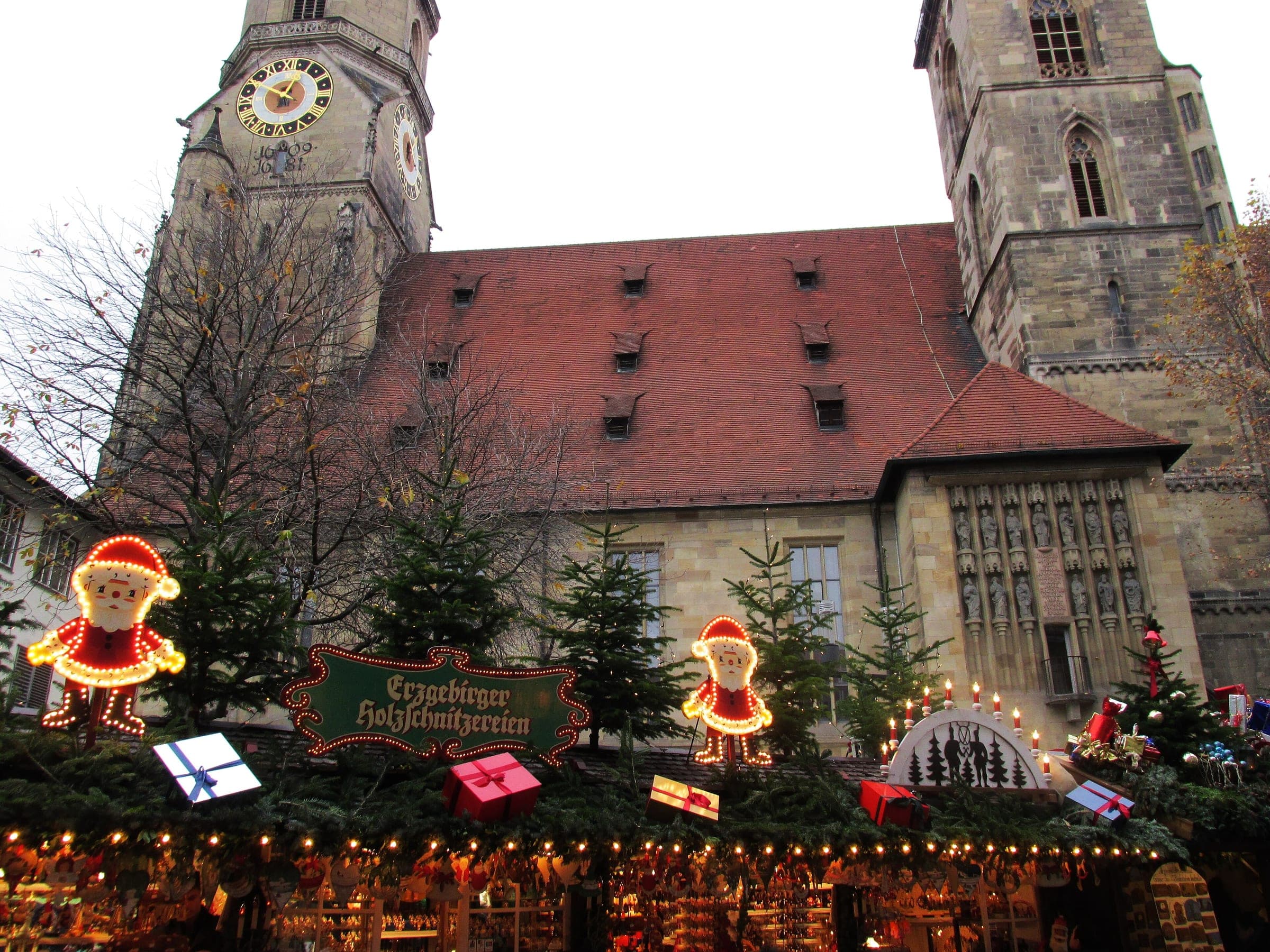 Decorated stall roofs of the Stuttgart Christmas Market sit below the twin towers of the Stiftskirche.