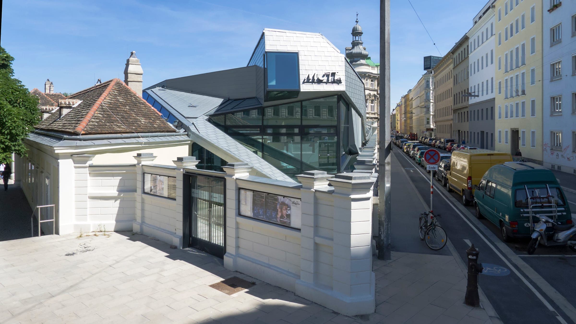 The angular glass and metal MuTh concert hall rises behind the old Augarten wall on Obere Augartenstrasse in Vienna.